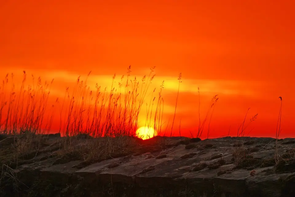 Couchée de soleil derrière une dune de sable.